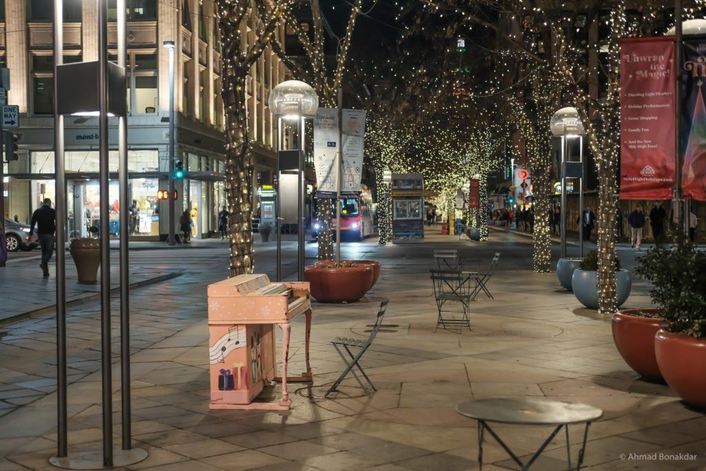 A pedestrian street with string lights in Denver at dusk