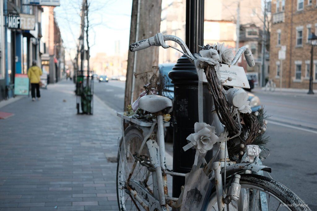 A bicycle locked to a post on a Toronto sidewalk